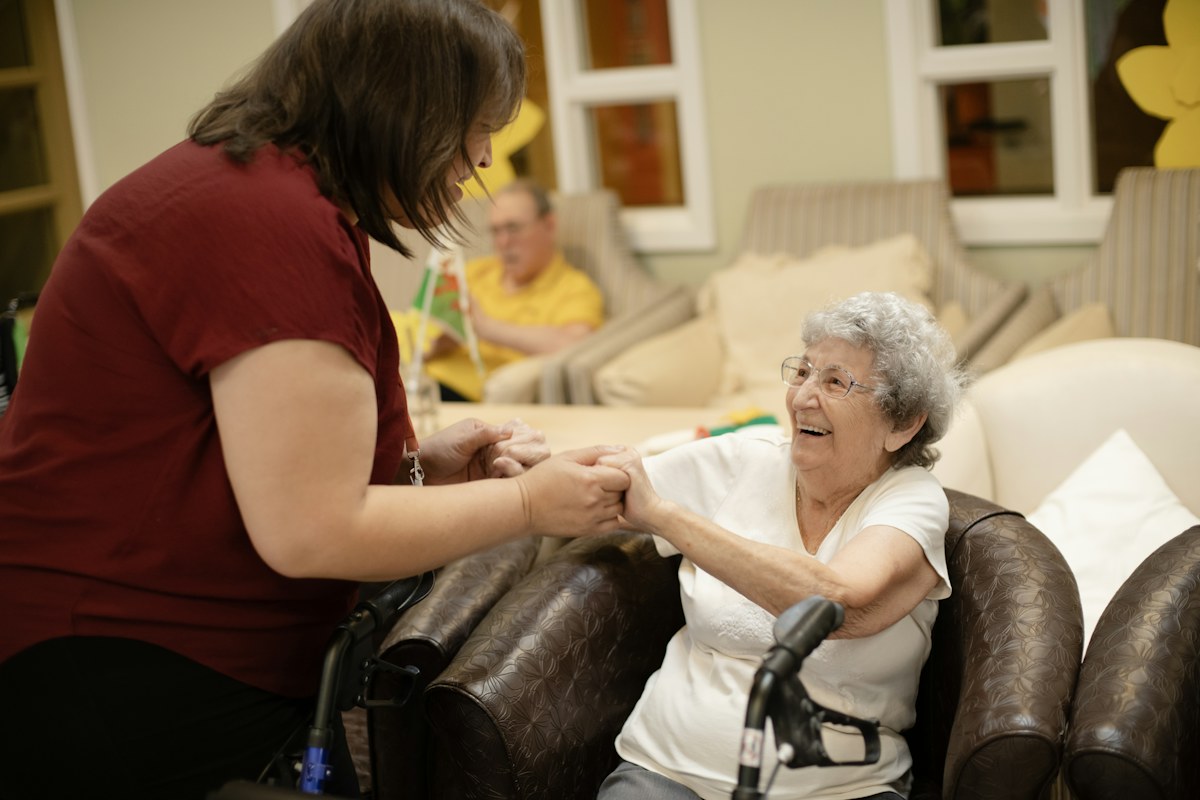 Caregiver supporting an older woman